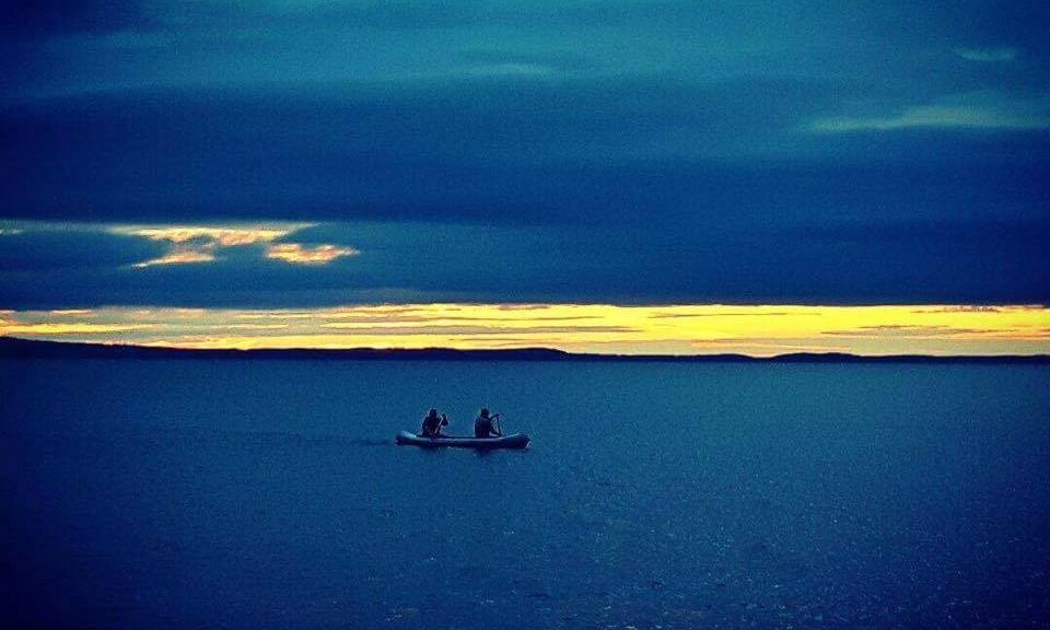 kaksi melojaa intiaanikanootilla Näsijärvellä auringonlaskun aikaan
